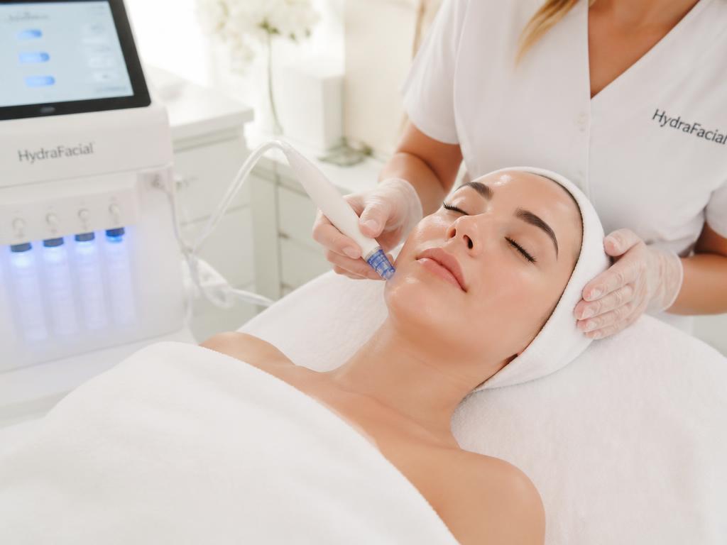 HydraFacial vortex-fusion wand gliding across a client's cheek